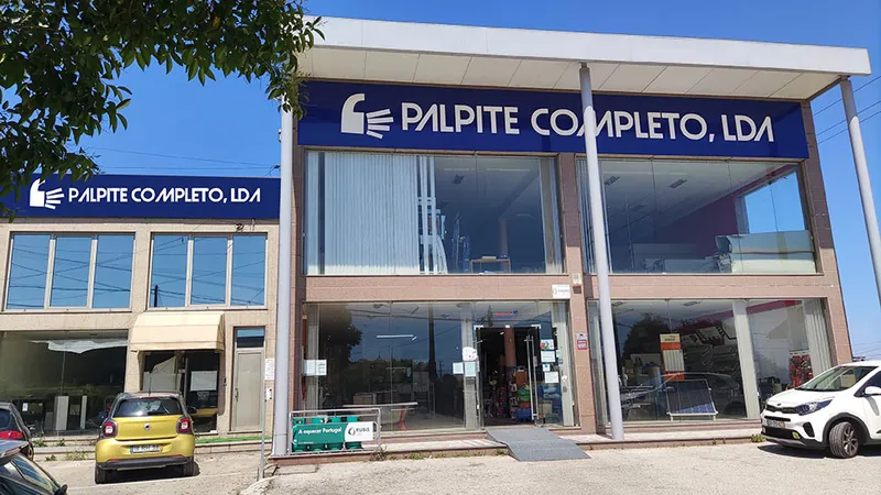 Fachada da loja com o letreiro azul Palpite Completo